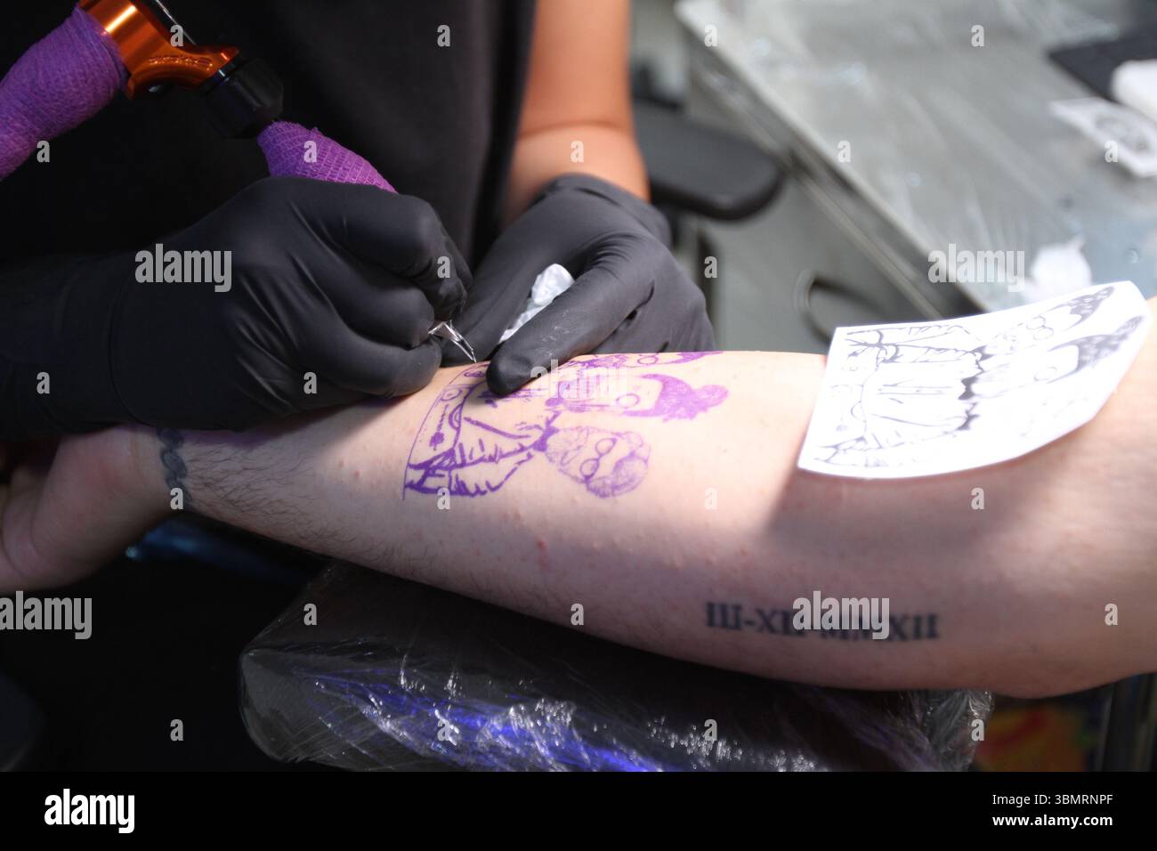 Servizio fotografico in stile documentario per catturare il processo di tatuaggio e i disegni Foto Stock