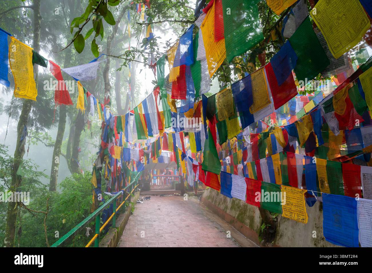 Darjeeling, Bengala Occidentale, India-11.08.2023: Bandiere sulle scale nella foresta, via per il Tempio Mahakal o Mahakal Mandir, tempio indù dedicato al Dio Shiva. Foto Stock