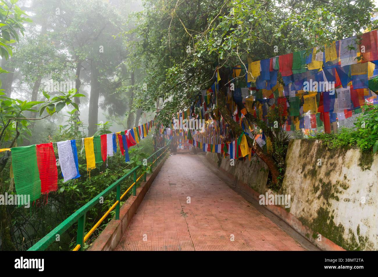Darjeeling, Bengala Occidentale, India-11.08.2023: Bandiere sulle scale nella foresta, via per il Tempio Mahakal o Mahakal Mandir, tempio indù dedicato al Dio Shiva. Foto Stock