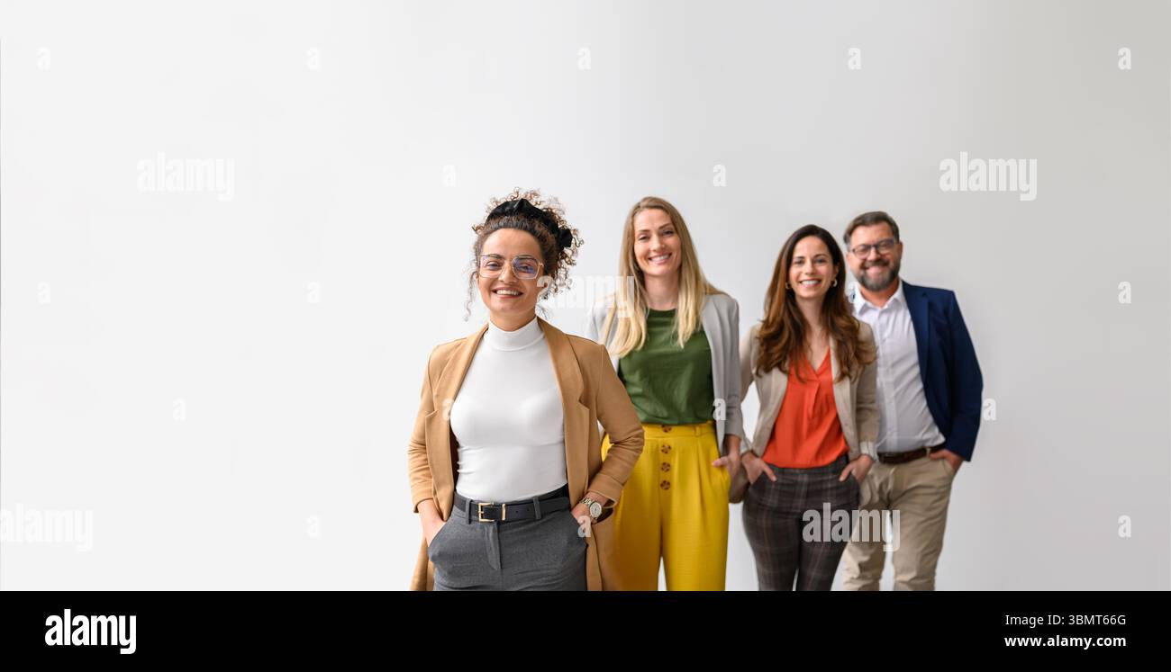 Ritratto di uomini d'affari sicuri con le mani in tasca sorridenti e in piedi in fila su sfondo bianco Foto Stock