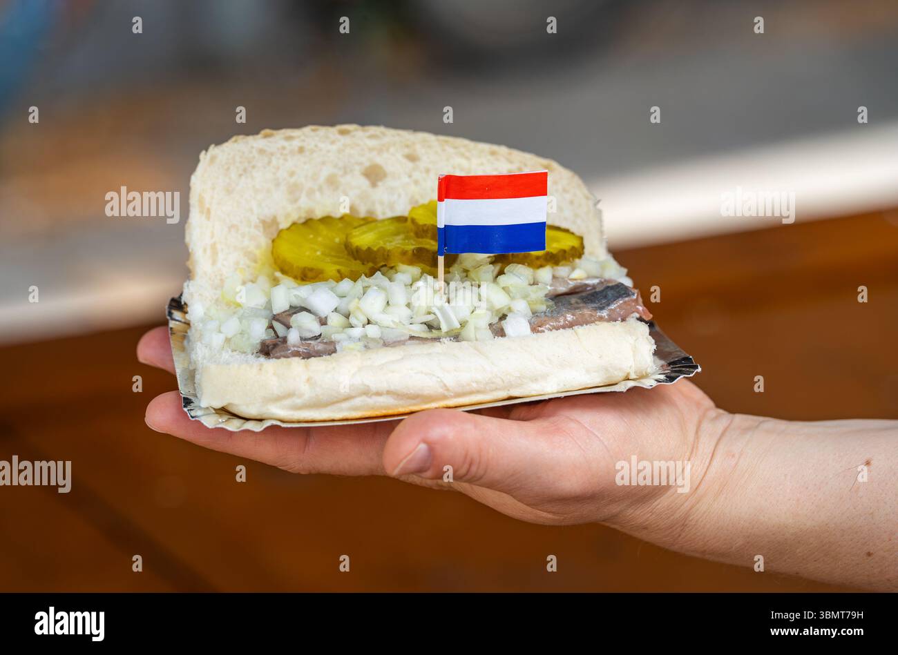 Panino alle aringhe, conosciuto nei paesi bassi come Broodje Haring, tipico spuntino olandese con aringhe, sottaceti e cipolla Foto Stock