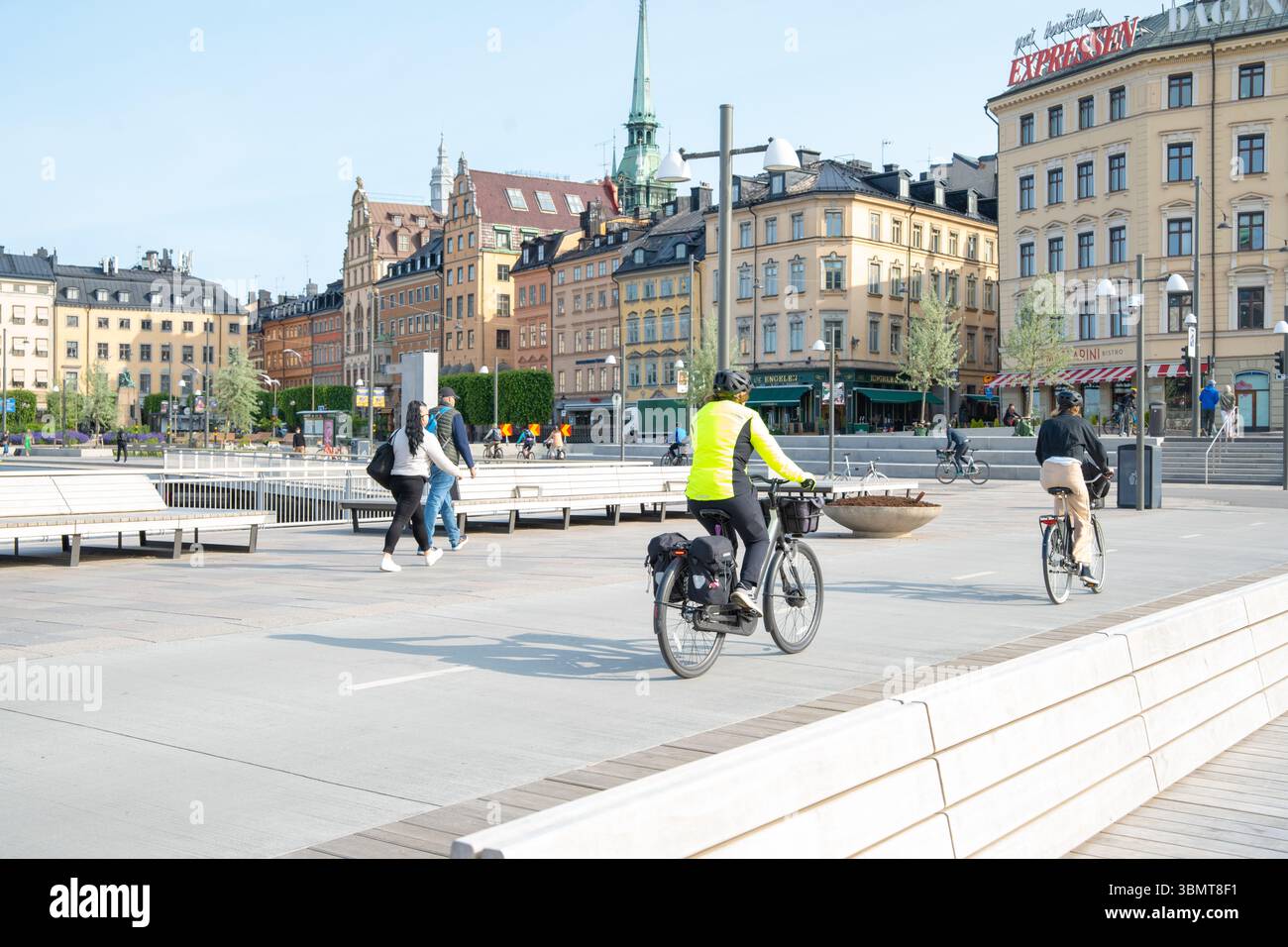 Ciclisti e pedoni che viaggiano in bicicletta dalla città vecchia di Slussen e Gamla Stan in una mattina d'estate in una città sostenibile Foto Stock