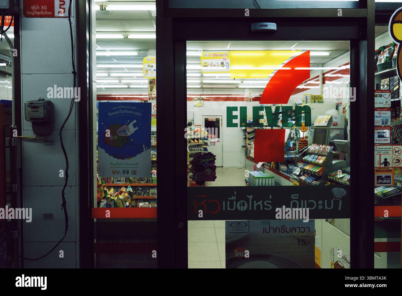 7-Eleven minimarket interno porta di vetro, vendita al dettaglio notturno in Thailandia Foto Stock