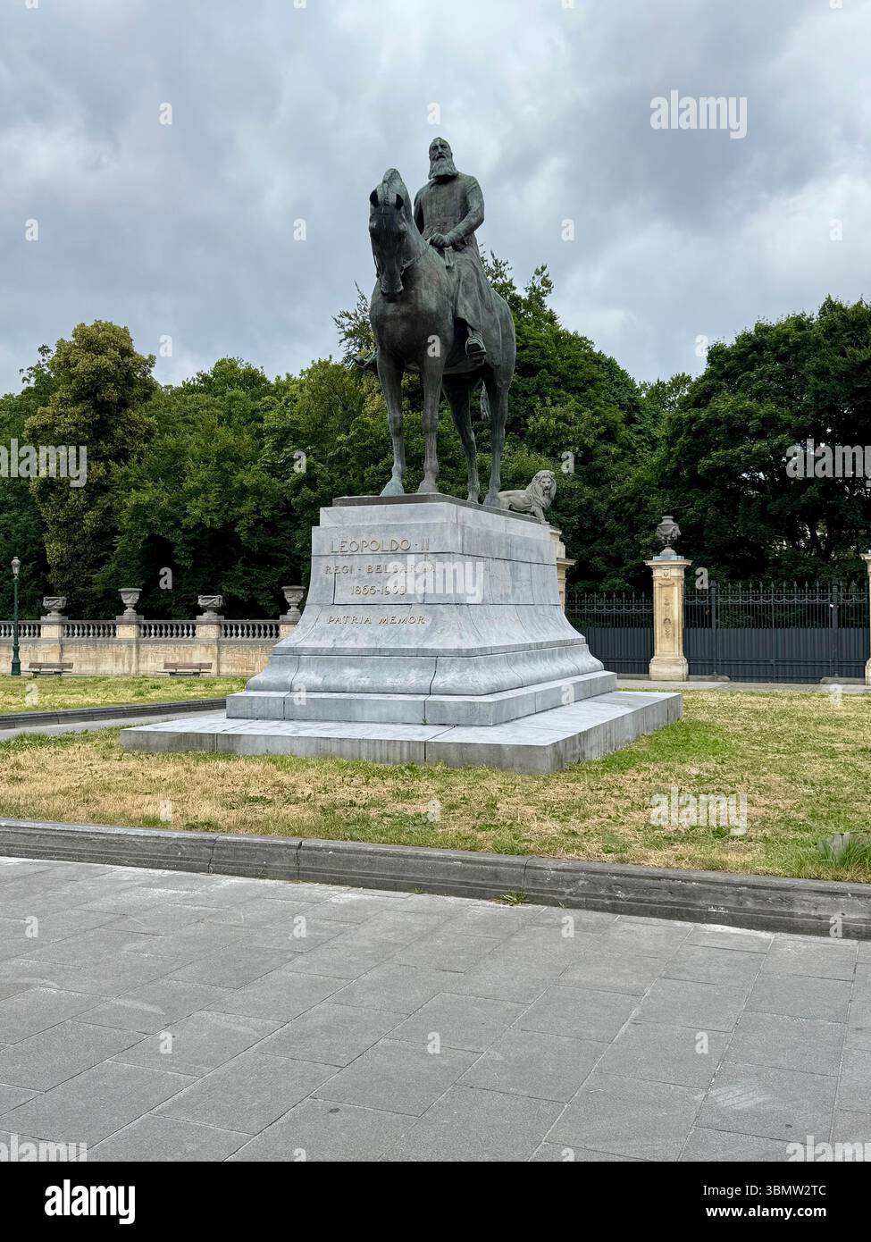 Statua equestre del re Leopoldo II a Bruxelles, Belgio, in piedi su un piedistallo in pietra in un parco urbano sotto un cielo nuvoloso. - Immagine stock catturata con smartphone