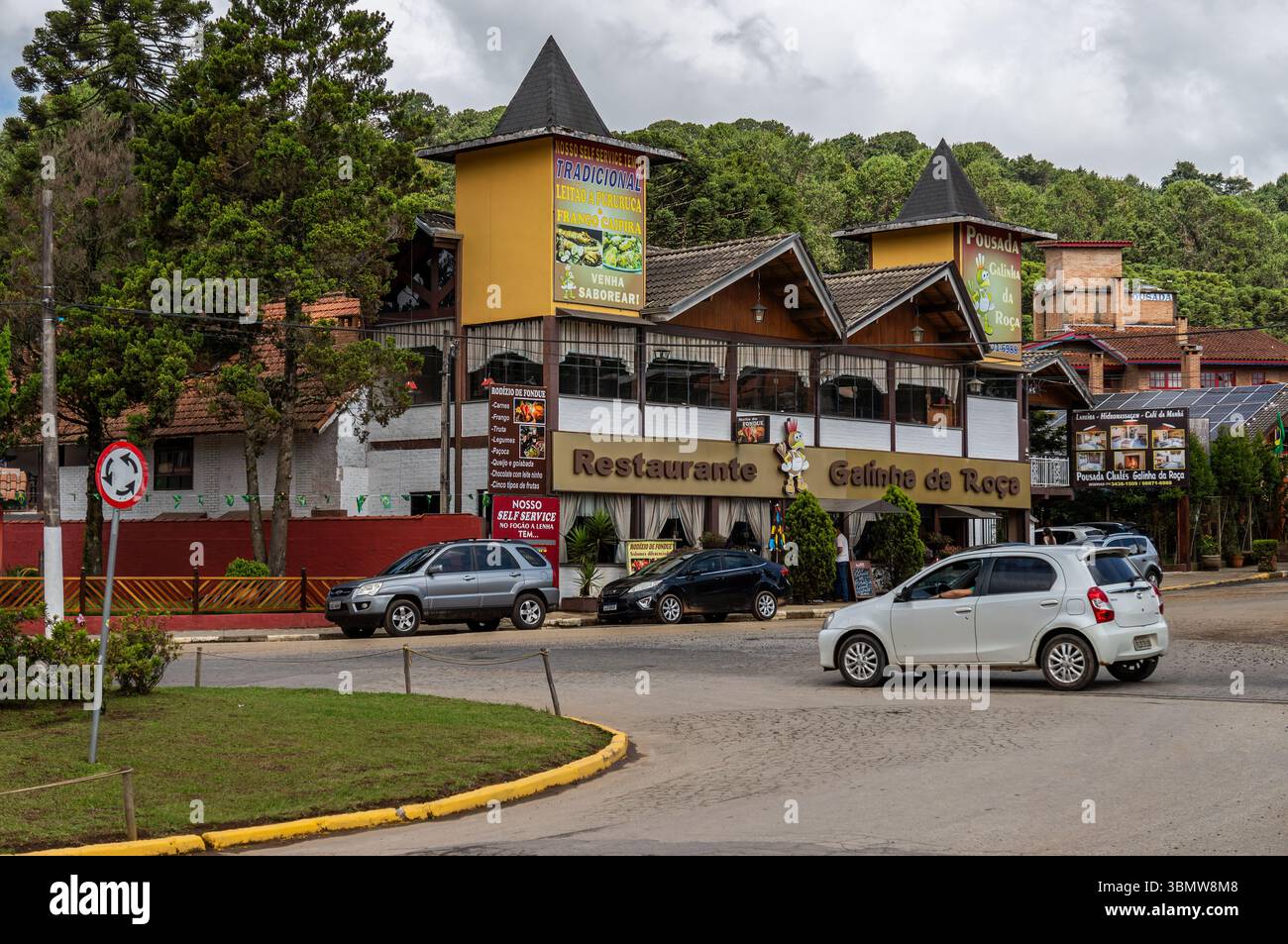Ristorante e locanda tradizionale in stile alpino con distintive facciate a torre alla rotonda del Monte Verde, circondato da vegetazione verde. Foto Stock