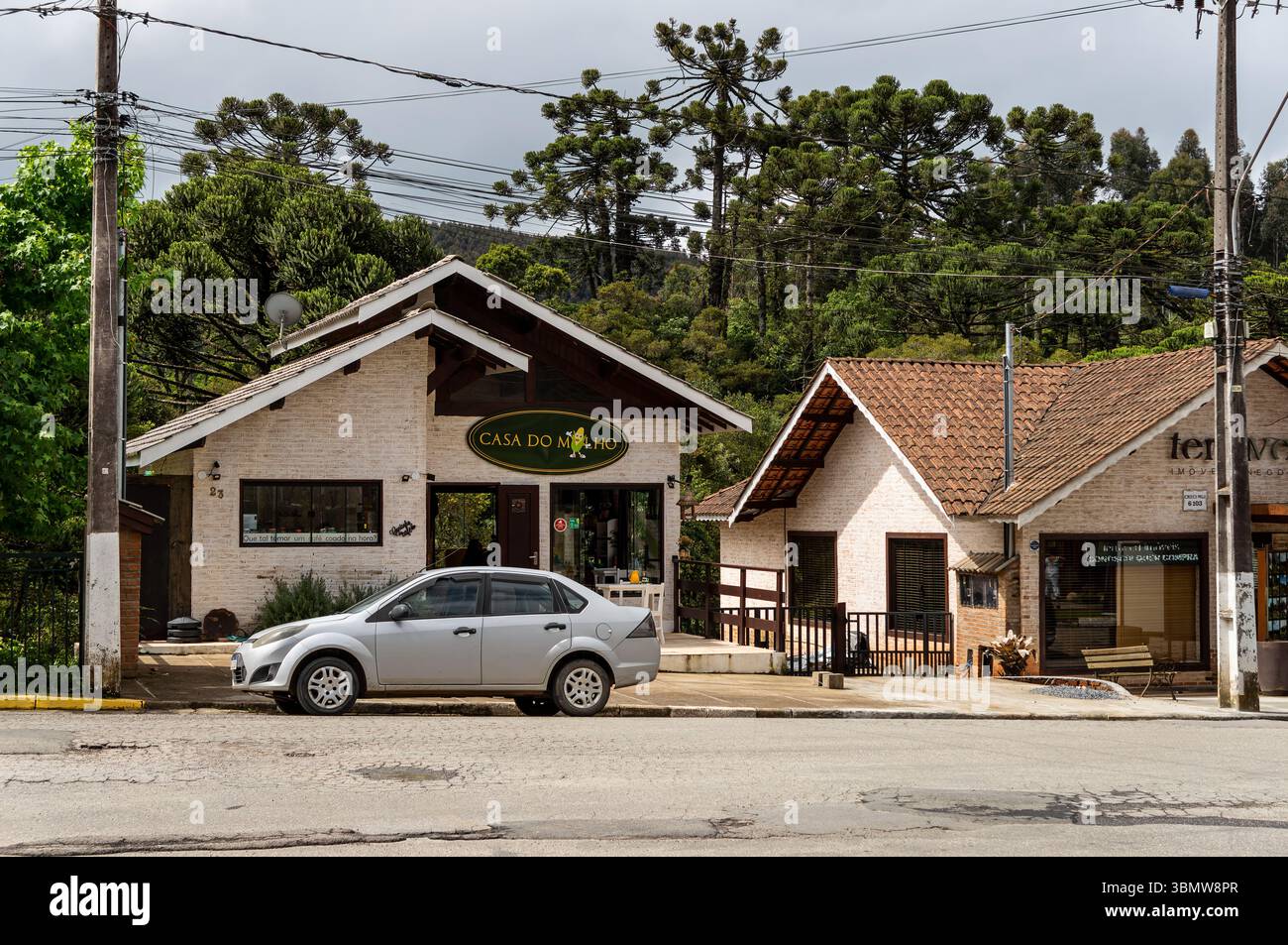 Negozi rustici in stile alpino con tetti in terracotta vicino all'ingresso del Monte Verde, con negozio di specialità di mais "Casa do Milho" presso LMG-886. Foto Stock