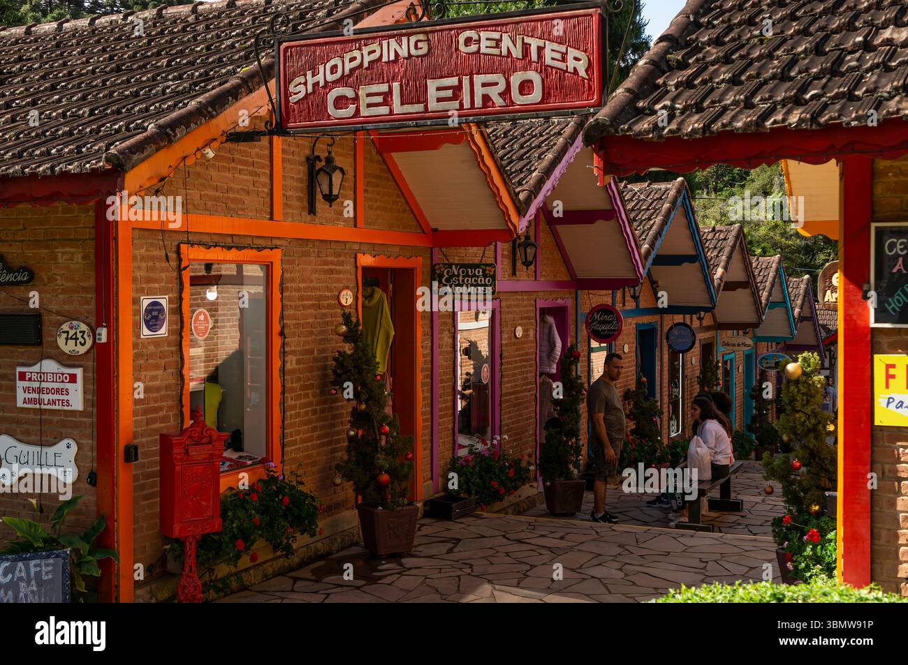 Passerella d'ingresso festiva del centro commerciale Celeiro in viale Monte Verde, con colorati negozi alpini, decorazioni natalizie e visitatori. Foto Stock