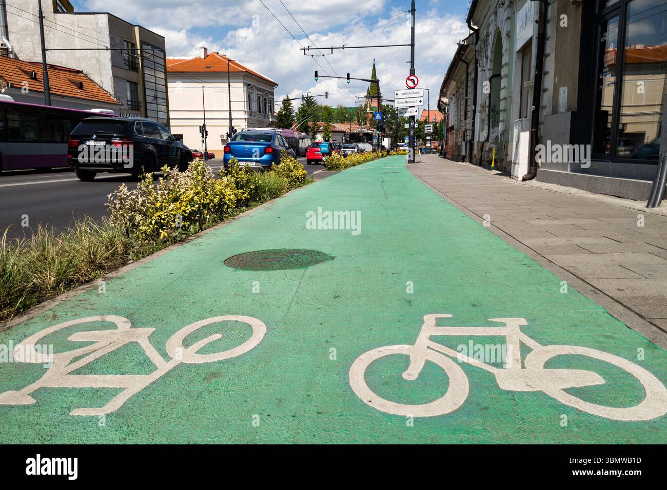 Cluj-Napoca, Romania - 25 giugno 2025: Una pista ciclabile verde a due vie corre lungo il marciapiede sulla Calea Motilor. Foto Stock
