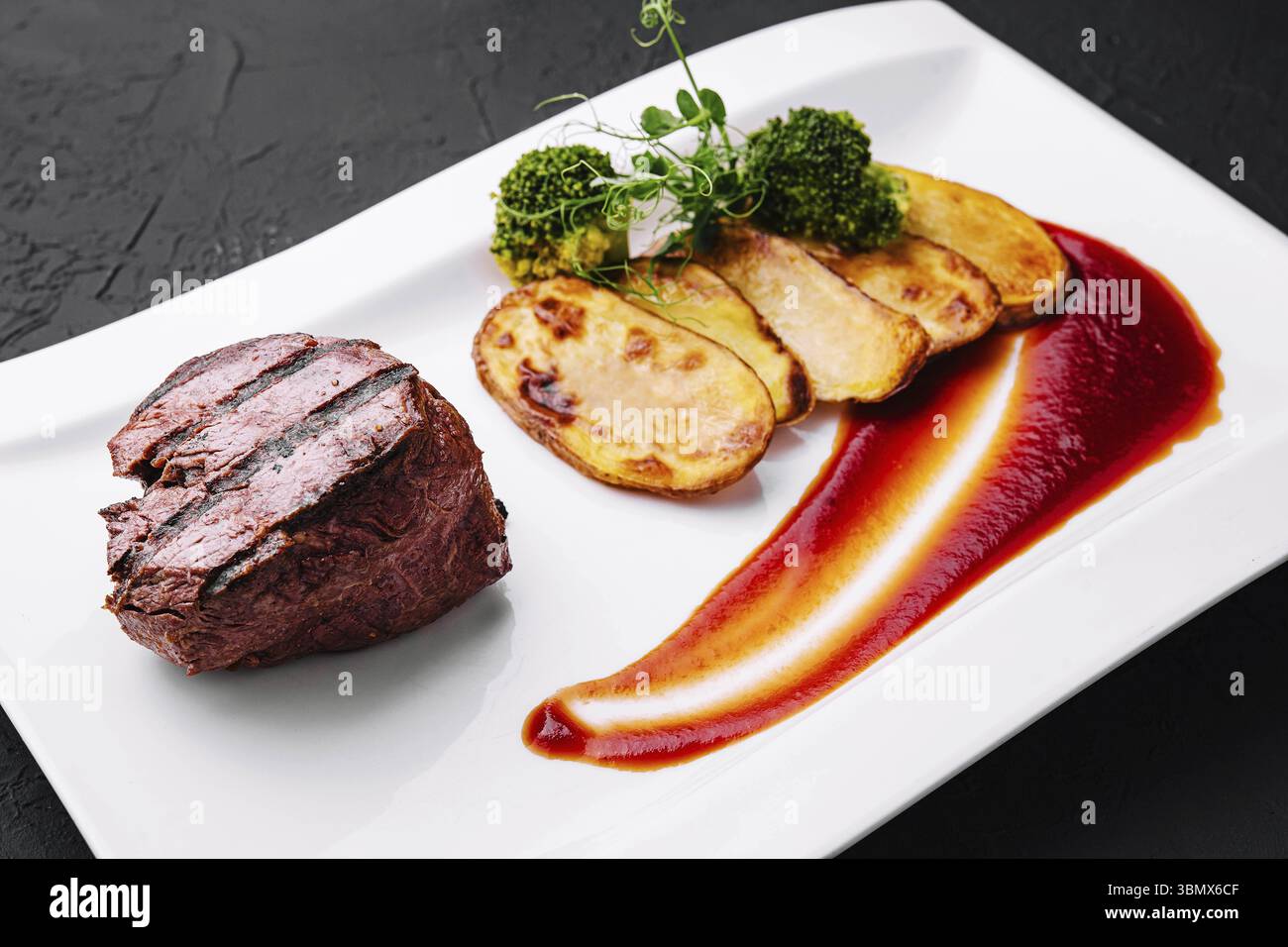 Cibo natura morta, appetitosa bistecca di manzo fritta con patate sul piatto Foto Stock