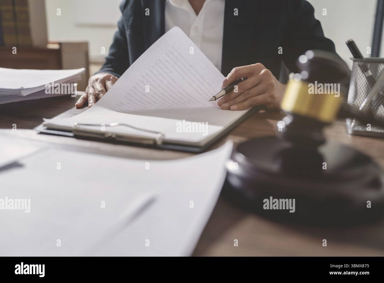 Avvocato di giustizia che sta considerando un documento legale in tribunale Foto Stock