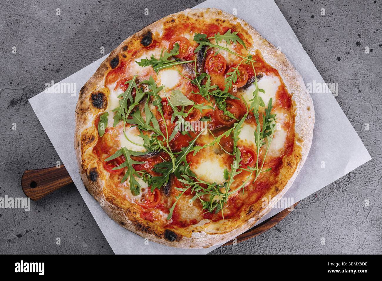 Cibo natura morta, Napoli Pizza o acciughe pizza su carta da forno Foto Stock