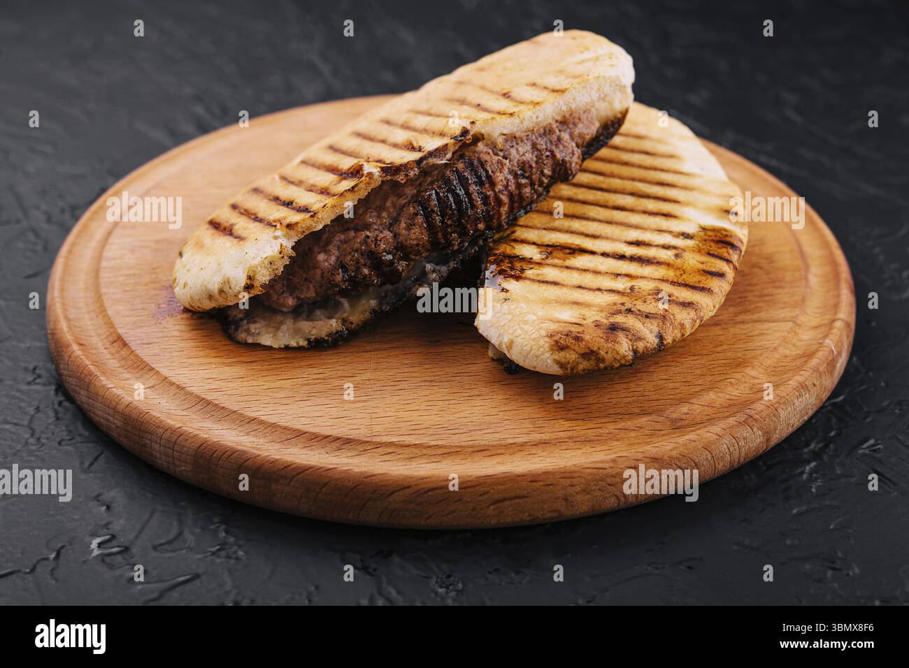 Cibo natura morta, pita fritta con bistecca di maiale su vassoio di legno Foto Stock