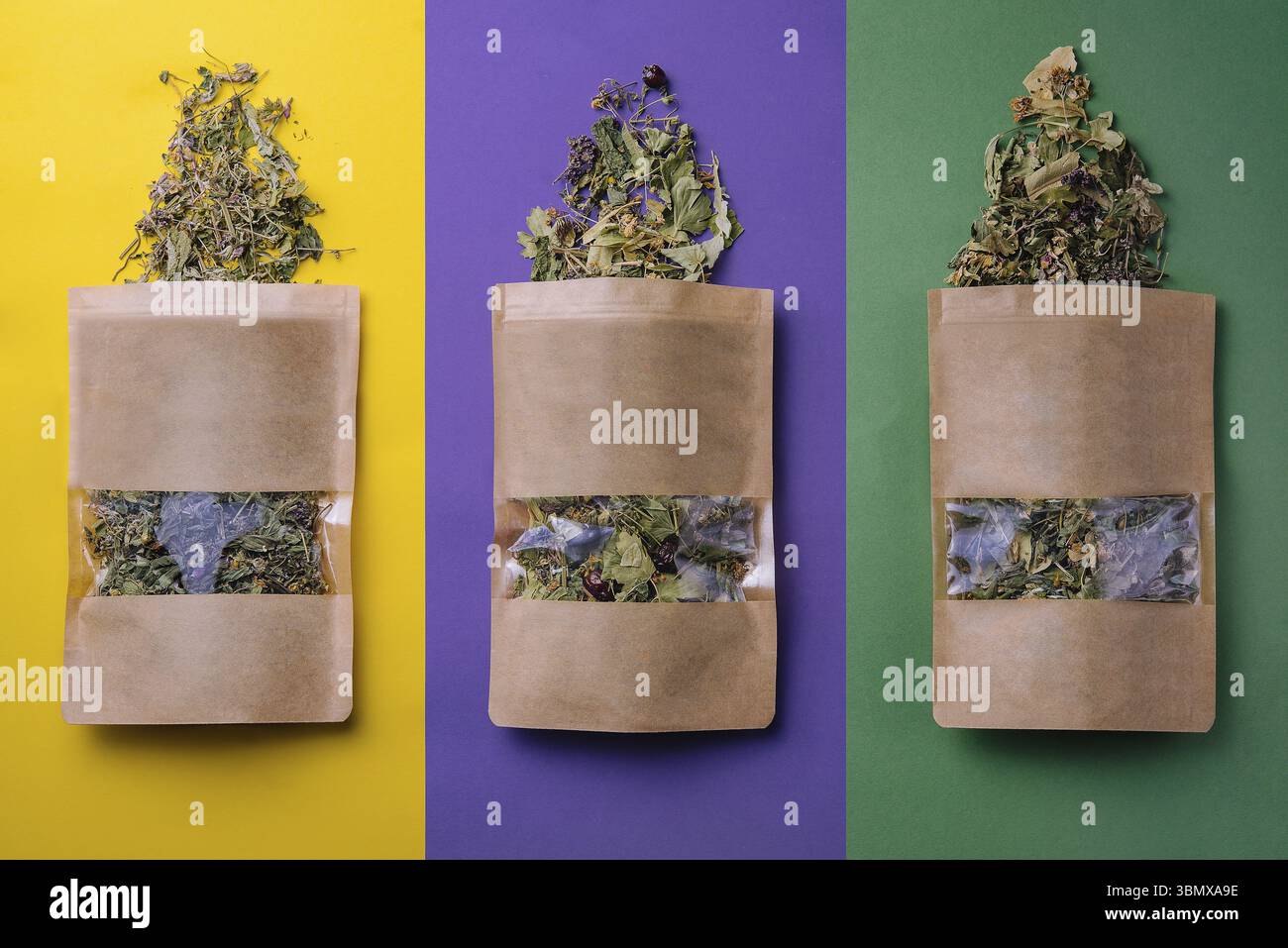 Natura morta alimentare, sacchetti di carta con diversi tipi di tè secchi sparsi Foto Stock