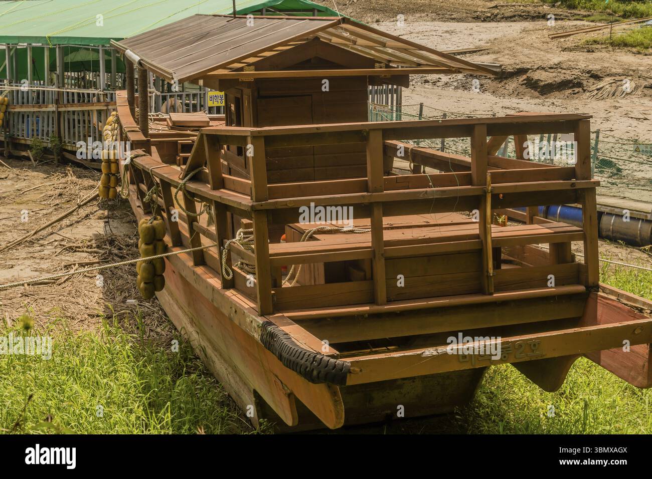 Geosan, Corea del Sud. 26 agosto 2020: Nave da tour in legno su un banco di sabbia di fronte alla casa galleggiante. con il lago sullo sfondo Foto Stock