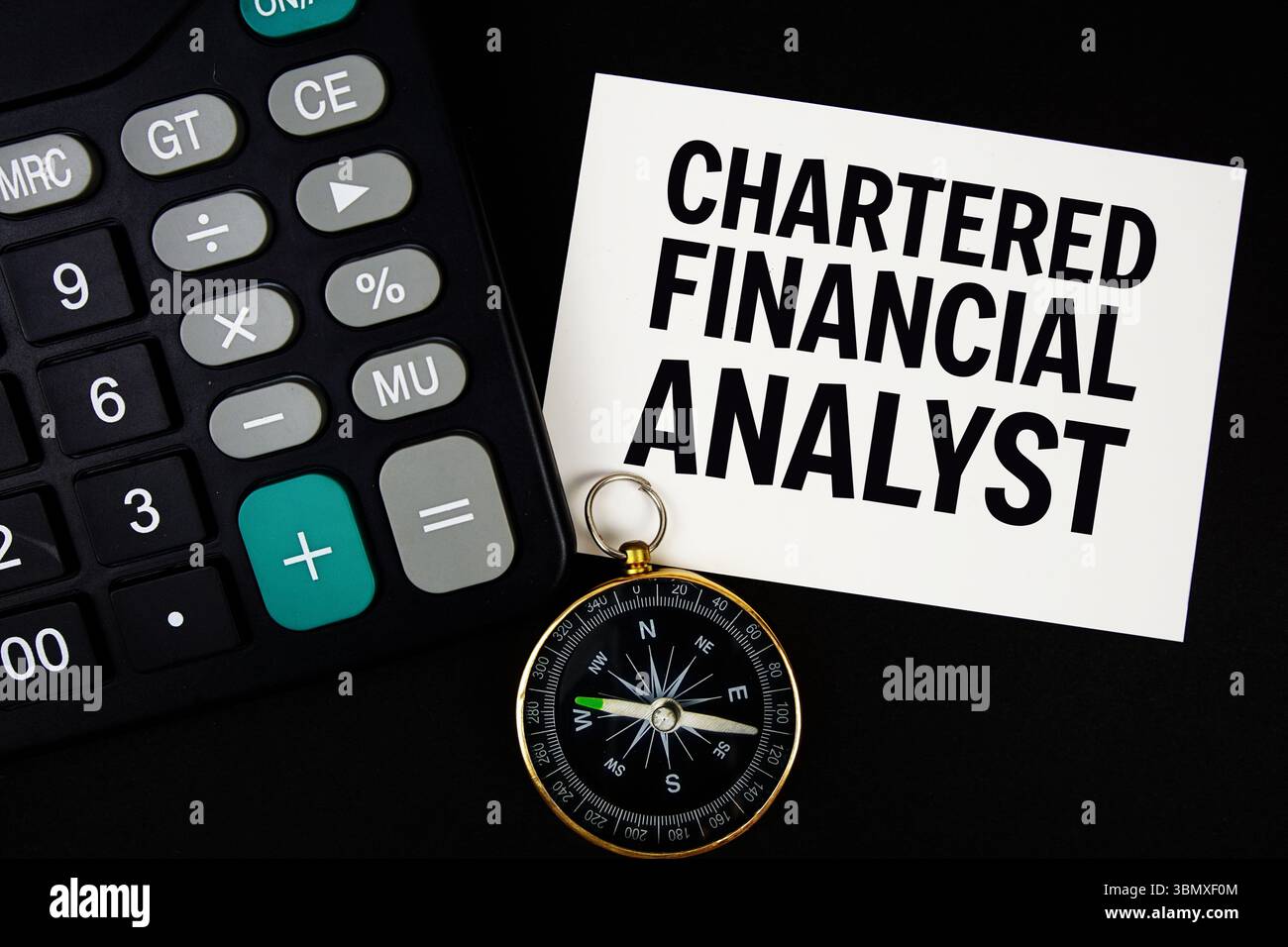 Testo Chartered Financial Analyst con bussola e calcolatrice su sfondo nero Foto Stock