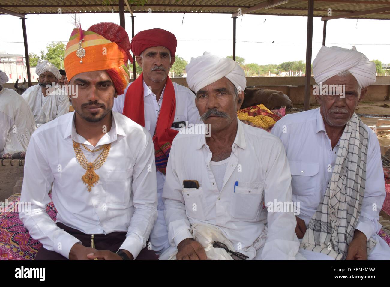 Uomini indiani rurali in abbigliamento tradizionale che indossano turbanti durante una riunione della comunità Foto Stock