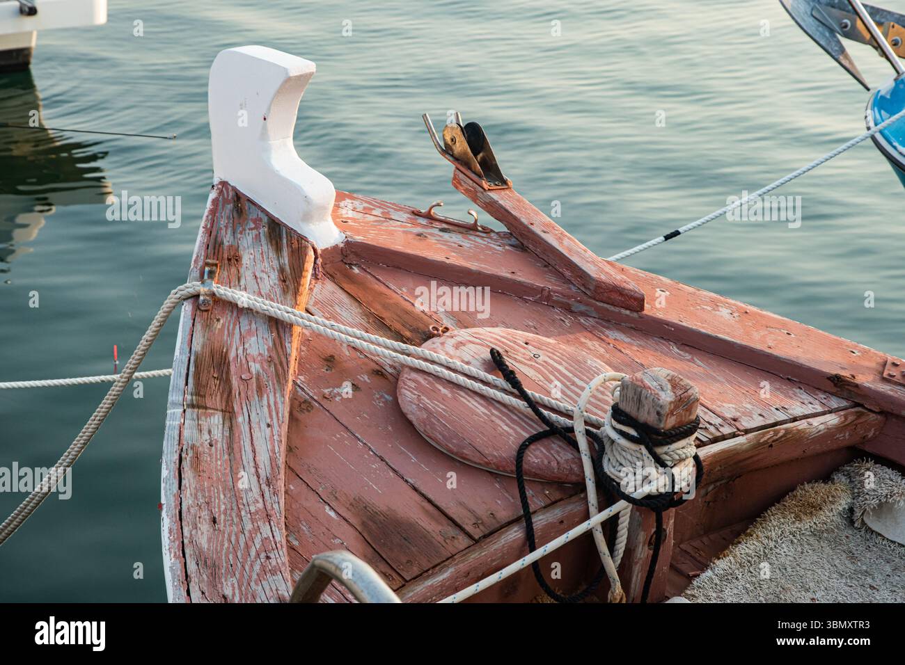 Inchina una barca da pesca in legno d'epoca nelle tranquille acque del porto, mostrando dettagli tradizionali Foto Stock