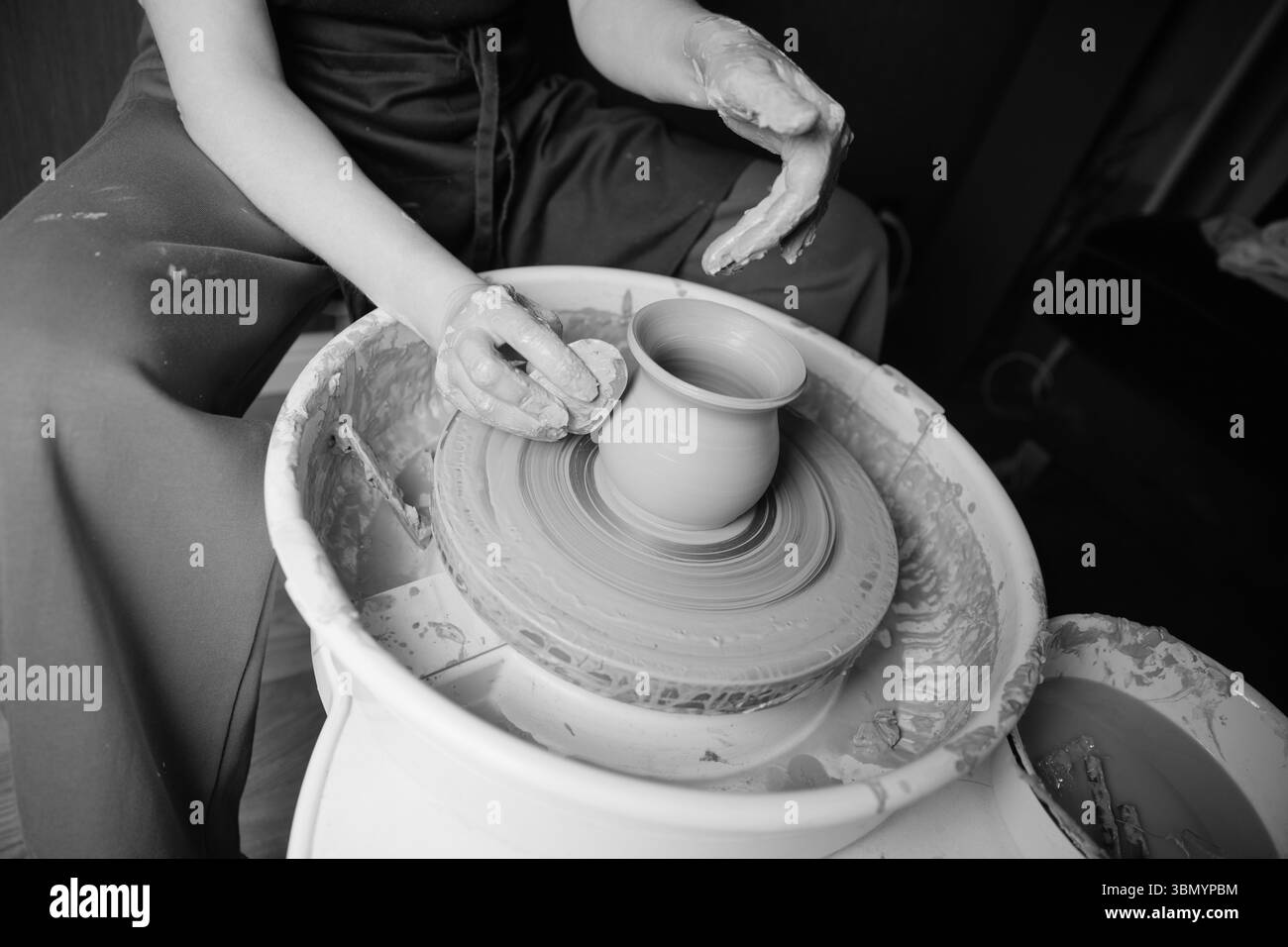 Ceramista che forma un'opera d'arte in ceramica su una ruota. Mani in argilla. Laboratorio di ceramica artistica Foto Stock
