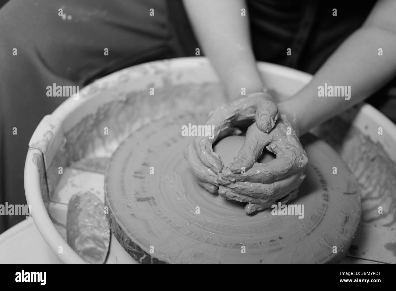 Ceramista che forma un'opera d'arte in ceramica su una ruota. Mani in argilla. Laboratorio di ceramica artistica Foto Stock