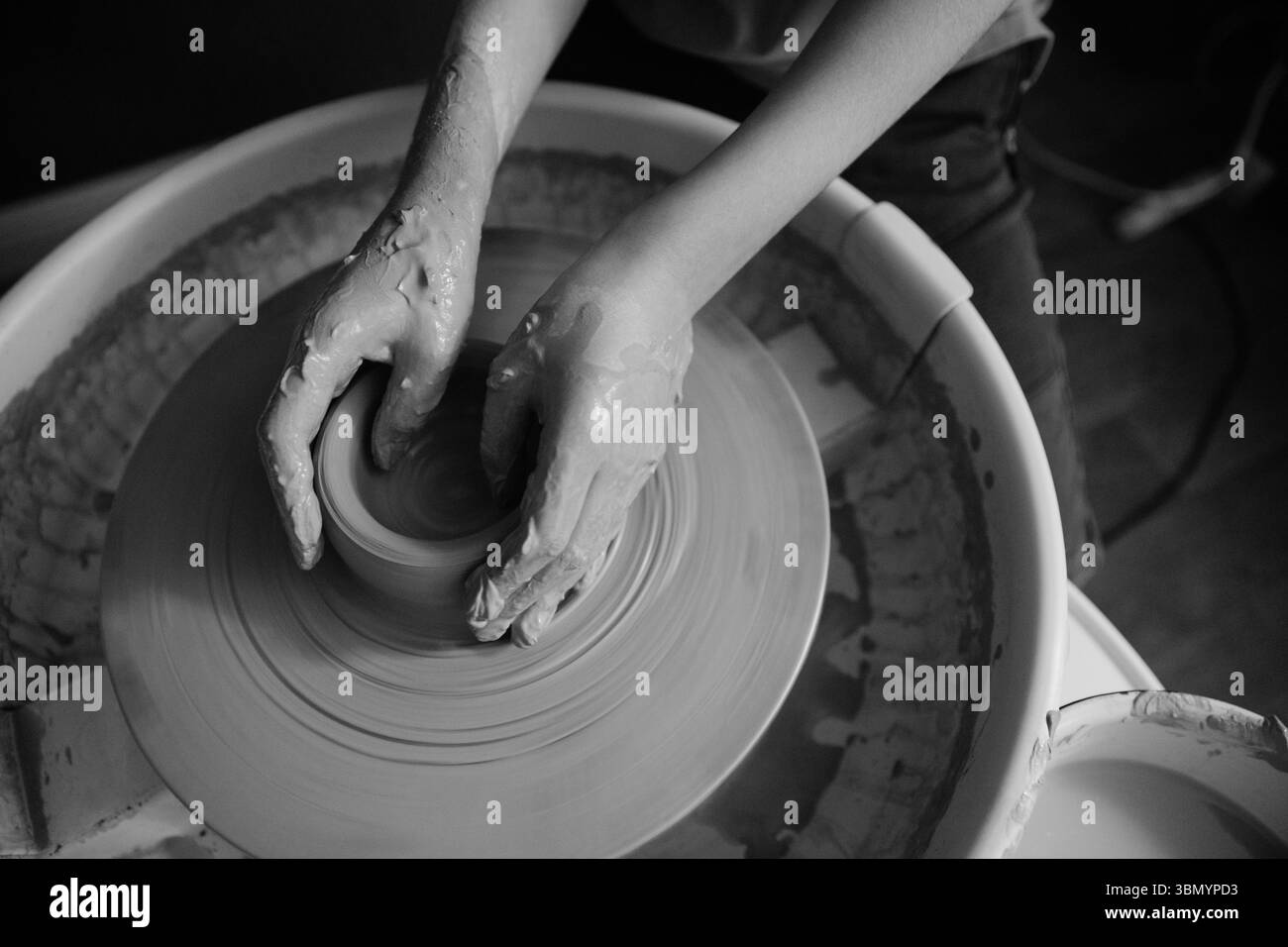 Ceramista che forma un'opera d'arte in ceramica su una ruota. Mani in argilla. Laboratorio di ceramica artistica Foto Stock