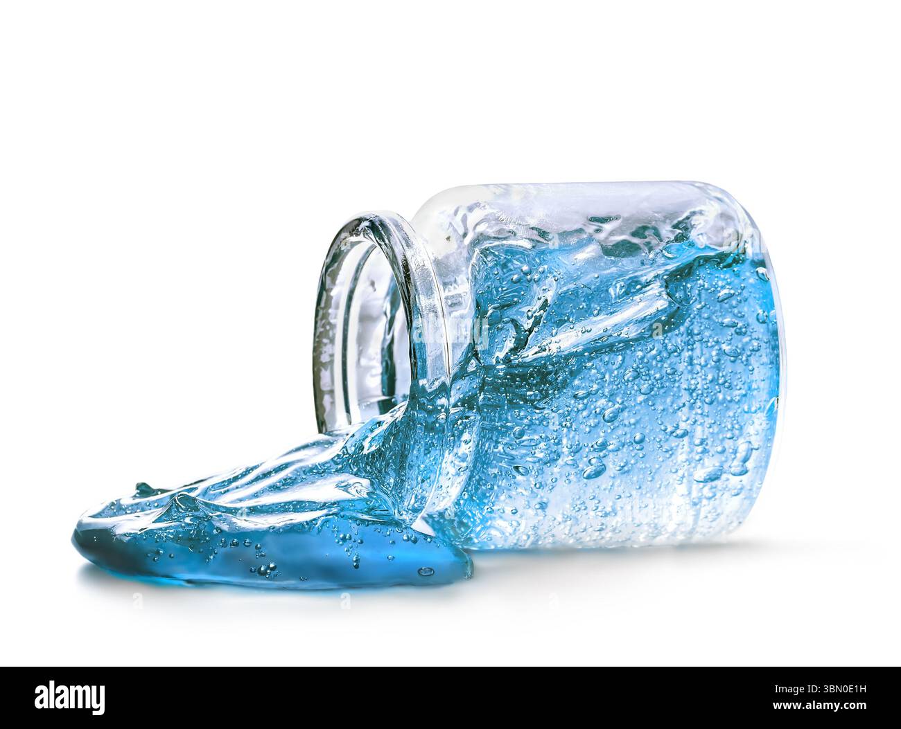 Il gel blu chiaro fuoriesce da un vaso di vetro su sfondo bianco Foto Stock