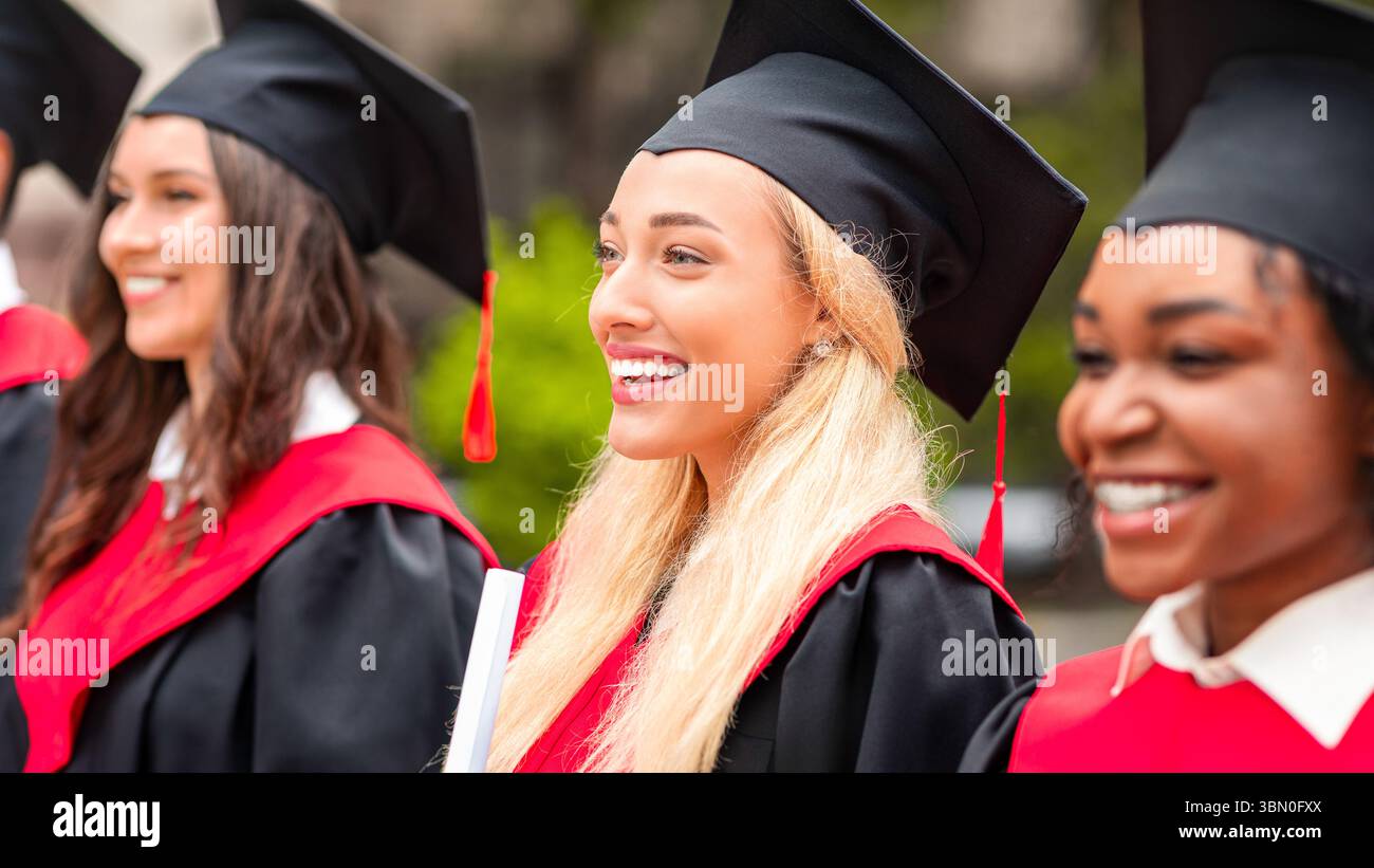 Bella signora bionda in piedi tra il gruppo internazionale di studenti Foto Stock