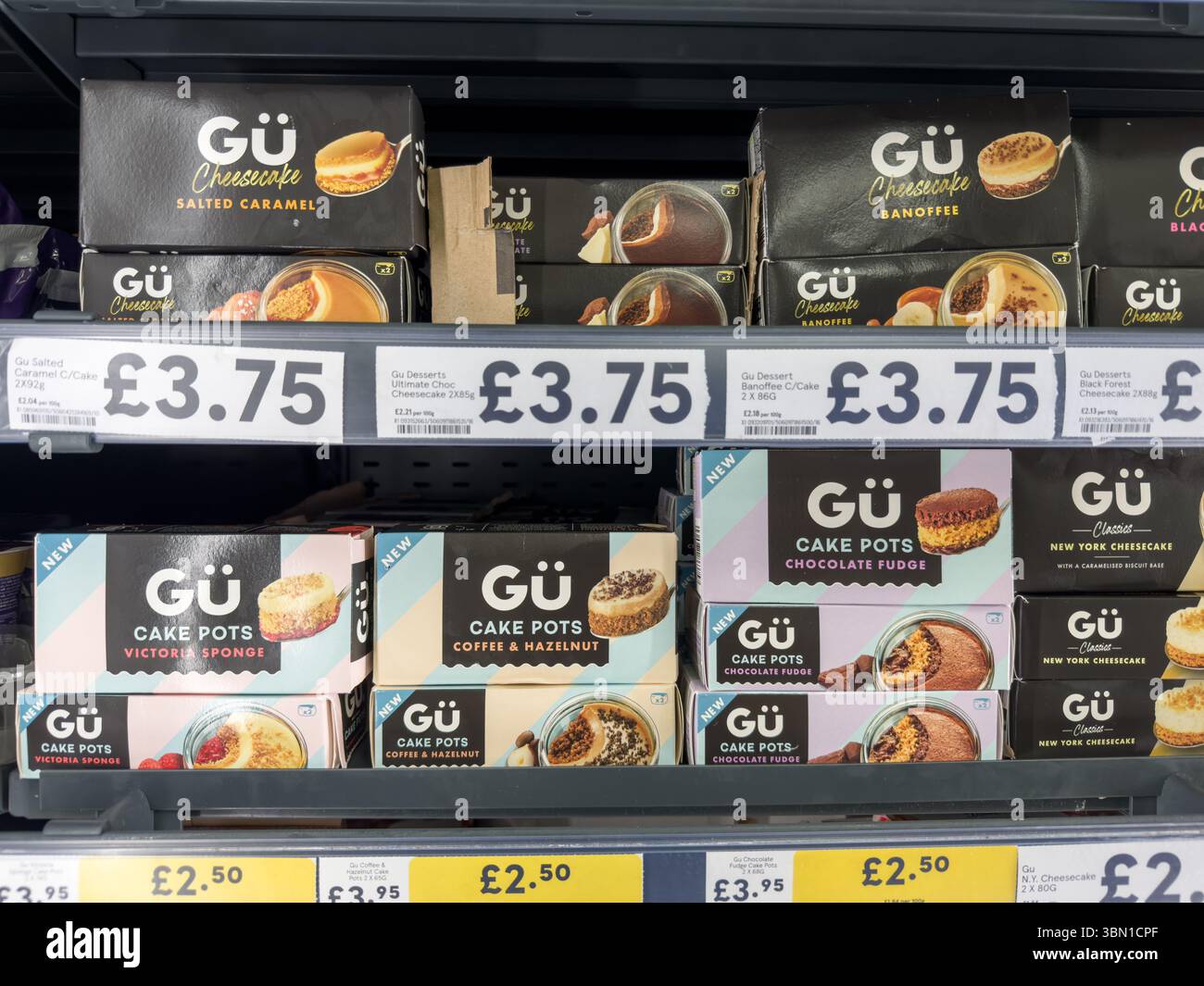 Selezione di dessert Gü di prima qualità con adesivi con sconto giallo esposti sugli scaffali dei supermercati a Londra, Regno Unito Foto Stock
