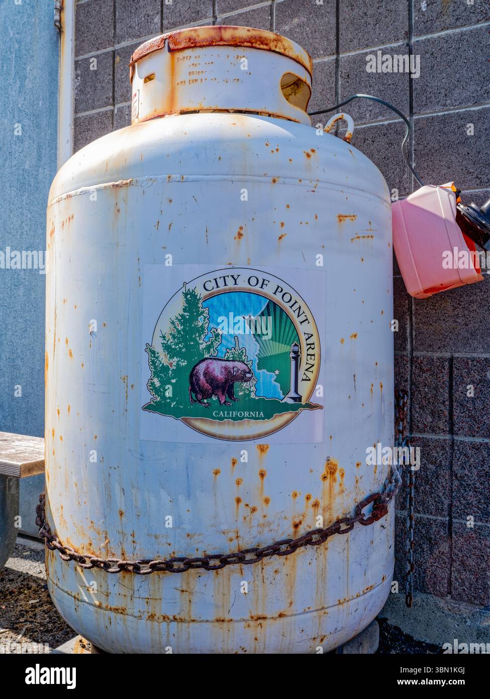 Una cisterna di propano arrugginita sul molo reca il logo della città a Point Arena, California, Stati Uniti Foto Stock