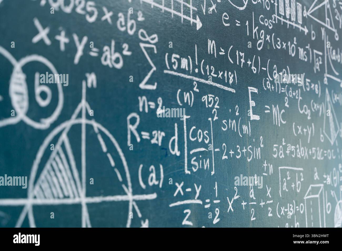 Vista ravvicinata di una lavagna coperta di equazioni matematiche, grafici e formule scientifiche. Perfetto per contenuti su educazione, scienza, acad Foto Stock