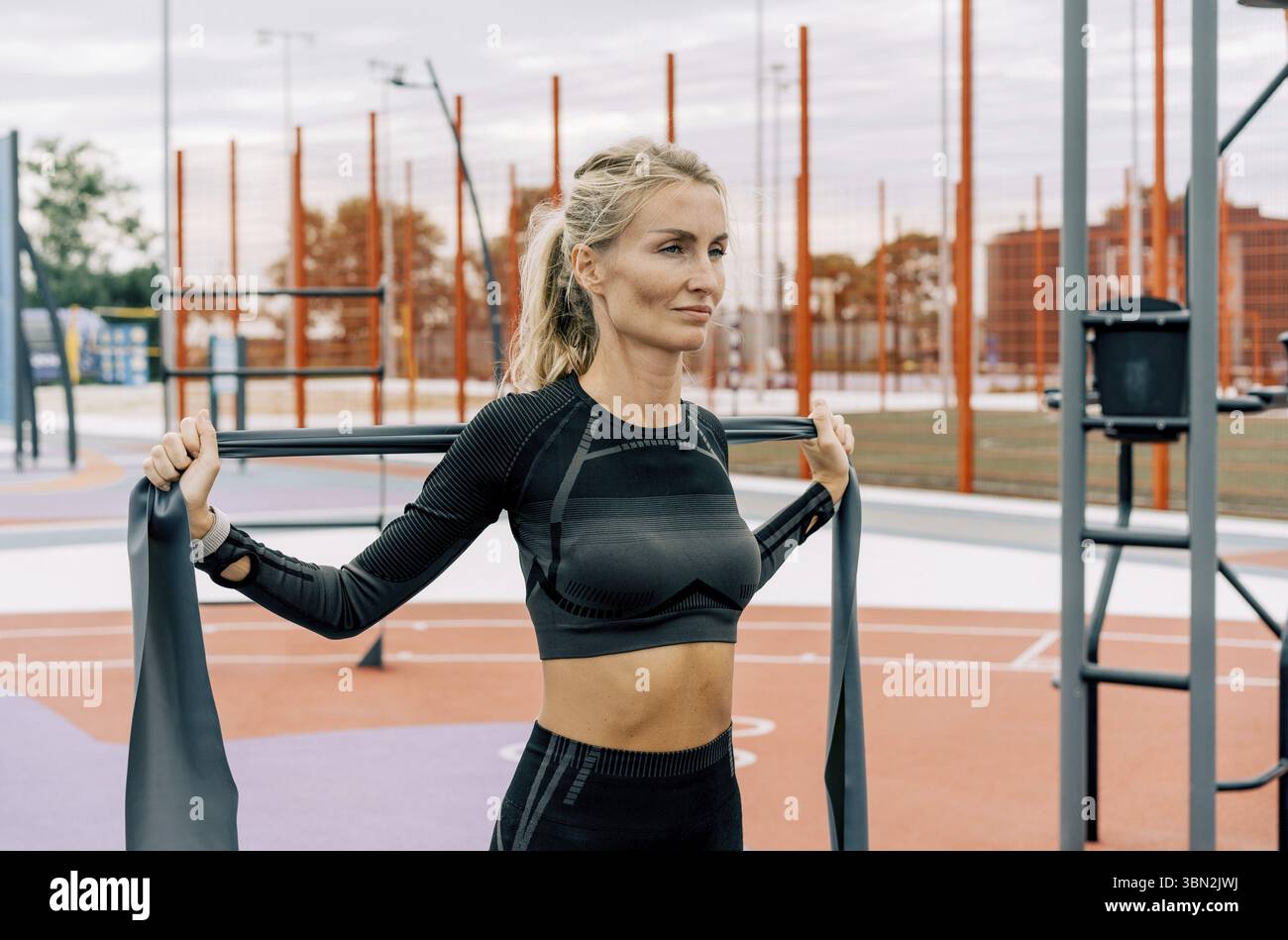 La giovane atleta si allena sul campo sportivo con fasce elastiche sportive Foto Stock