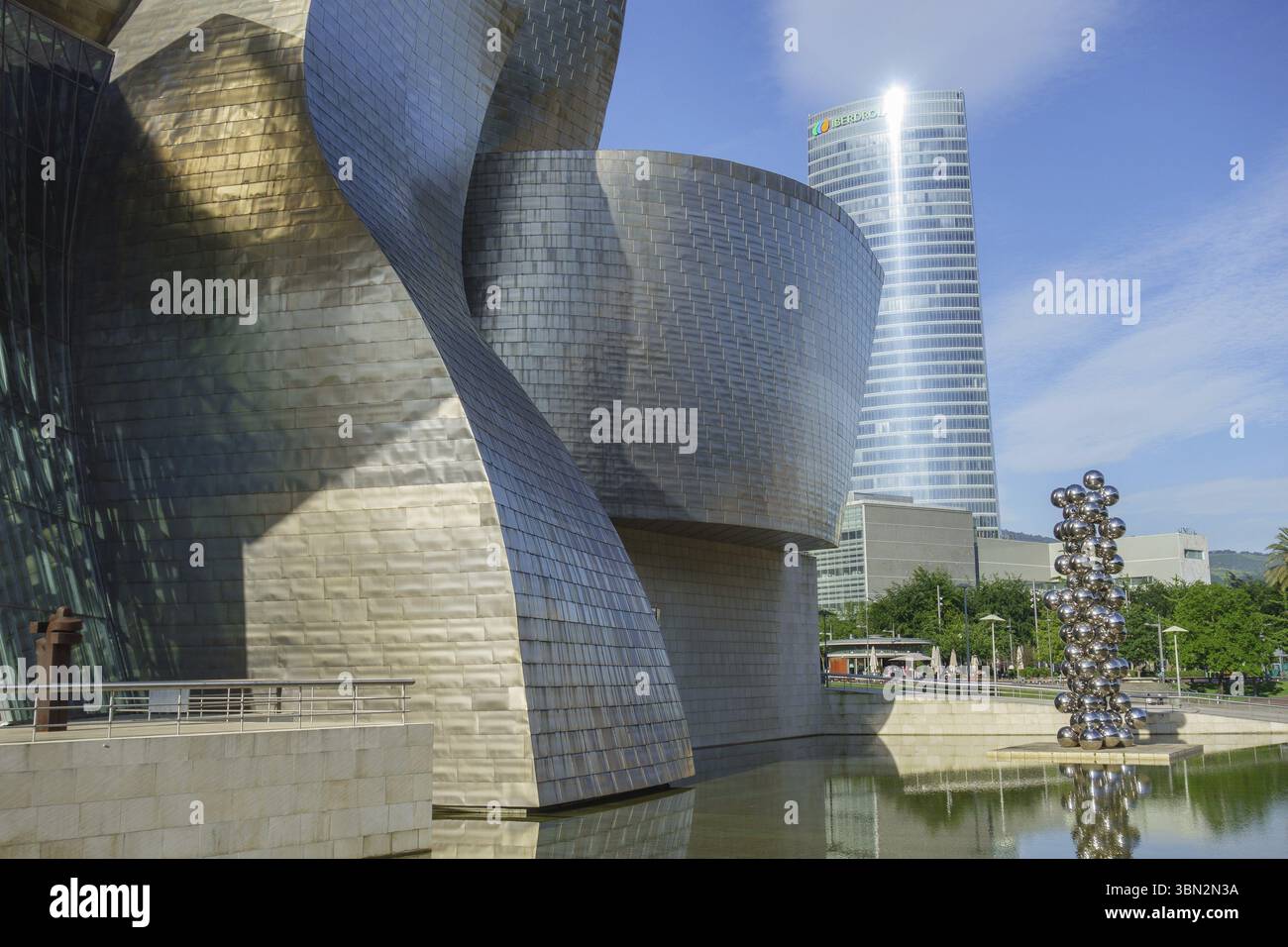 Moderno edificio in metallo con grattacielo sullo sfondo alla luce del giorno, Bilbao, Paesi Baschi, Spagna, Europa Foto Stock