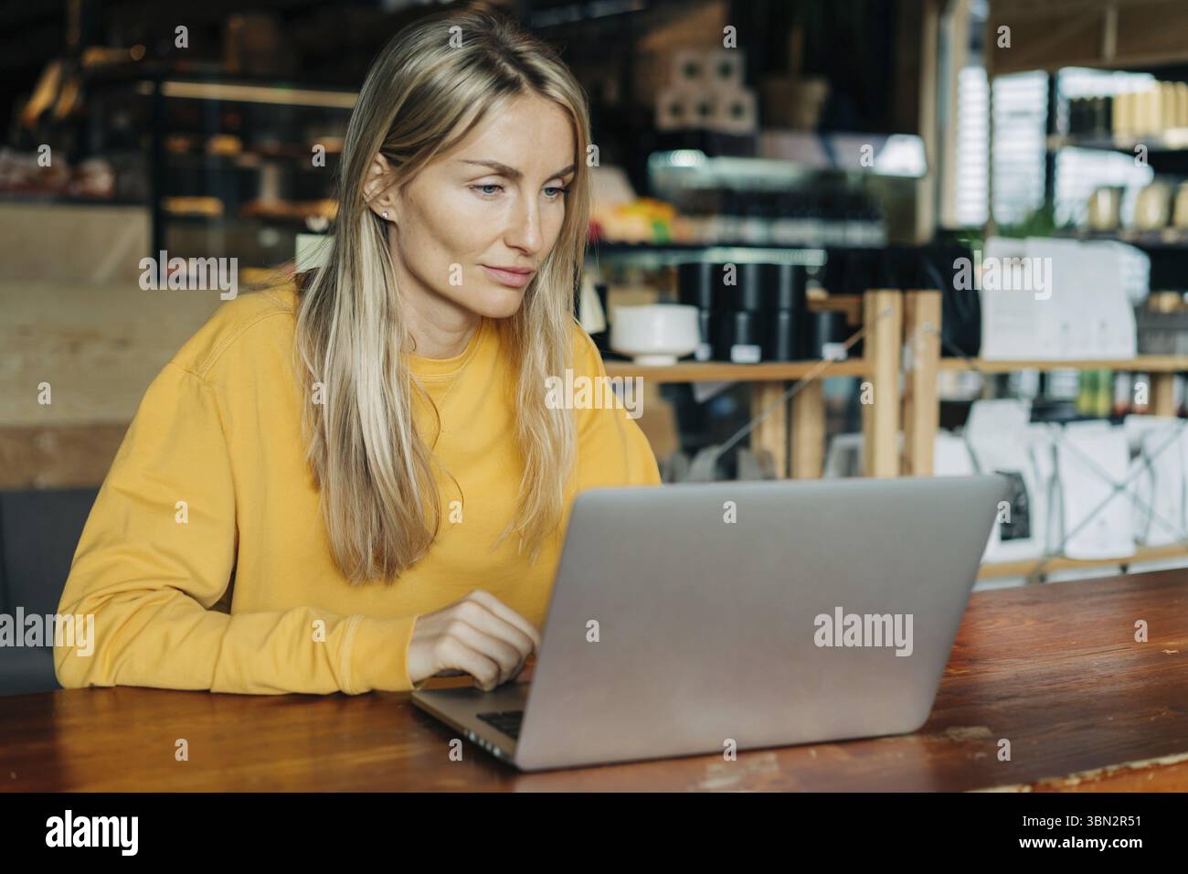 Kaukasische Frau arbeitet in einem Cafe an einem Lapto Foto Stock