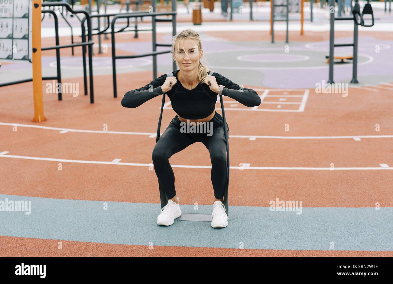 La giovane atleta si allena sul campo sportivo con fasce elastiche sportive Foto Stock