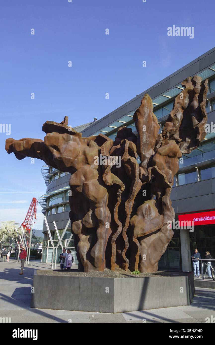 Grande scultura in metallo arrugginito di fronte a un edificio moderno, Bilbao, Paesi Baschi, Spagna, Europa Foto Stock