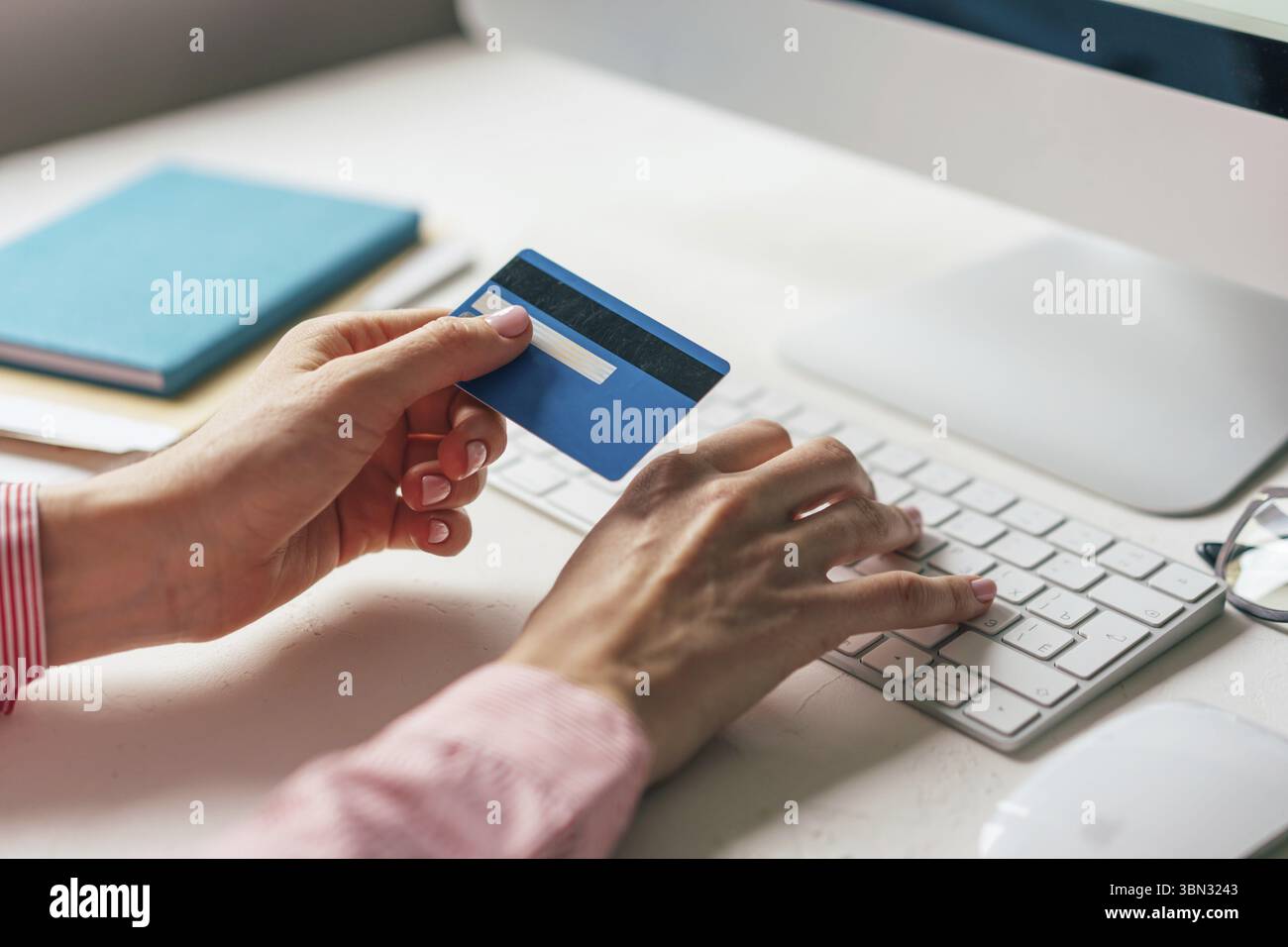 Nahaufnahme einer Kreditkarte in den Haenden, die auf einer Tastatur tippen. Arbeit von zu Hause. Shopping online mit Lieferung nach Hause. Internetba Foto Stock