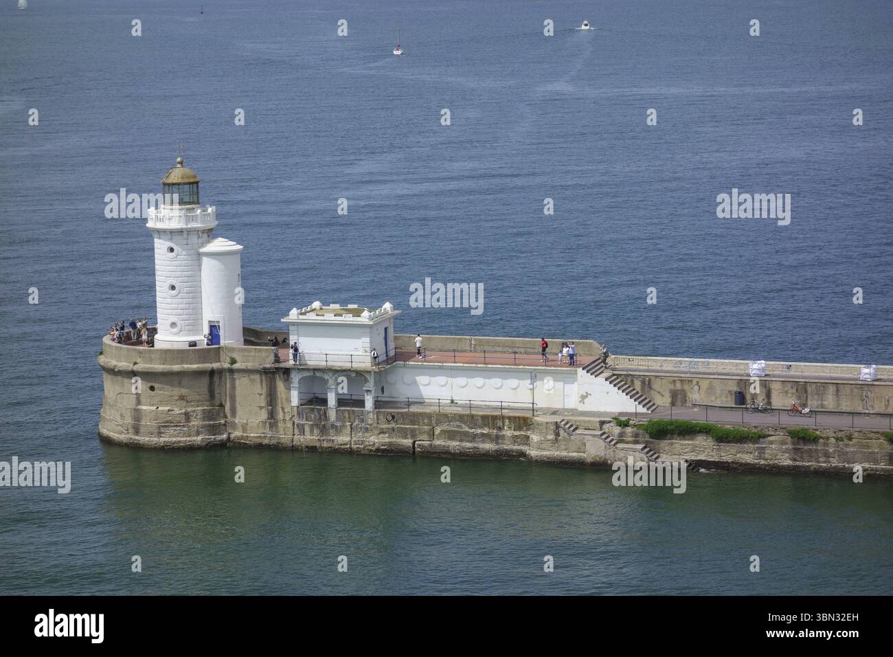 Un faro sorge su una frangiflutti circondata da acqua, Bilbao, Paesi Baschi, Spagna, Europa Foto Stock