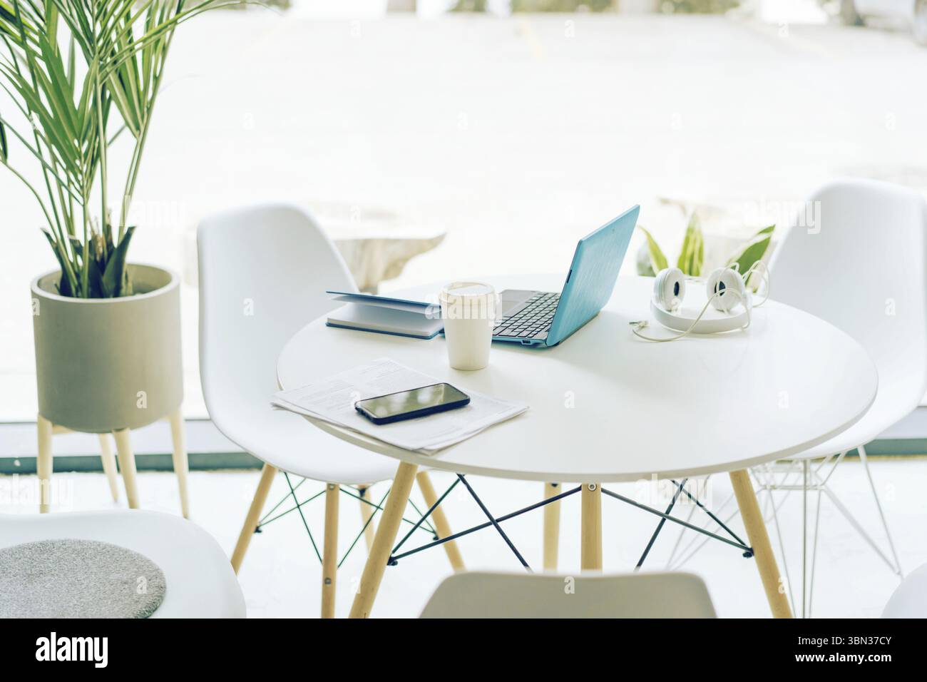Posto di lavoro di un imprenditore in un bar luminoso. Interni con illuminazione minima Foto Stock