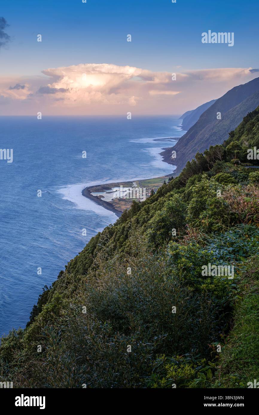 Scogliere costiere e paesaggio faja nell'isola di Sao Jorge, Azzorre Portogallo. Vista sull'oceano Atlantico, costa vulcanica, vegetazione lussureggiante, portoghese Foto Stock