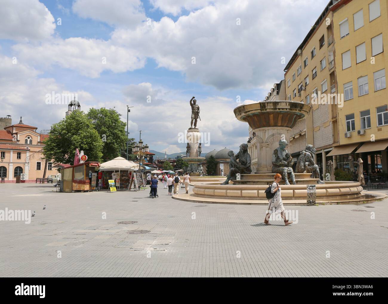 Skopje, Macedonia del Nord - 28 maggio 2025: Persone che camminano tra la Chiesa di San Demetrio e Piazza Macedonia Foto Stock