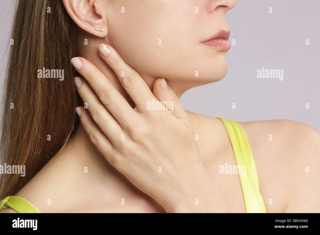 Donna caucasica che si tocca la gola. Mal di gola, raffreddore, influenza, tonsillite o problema della ghiandola tiroidea Foto Stock