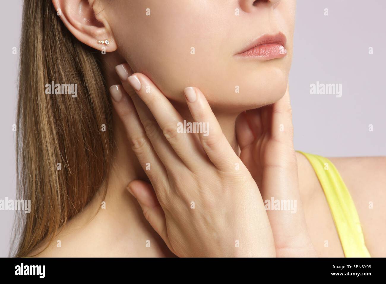 Donna caucasica che si tocca la gola. Mal di gola, raffreddore, influenza, tonsillite o problema della ghiandola tiroidea Foto Stock