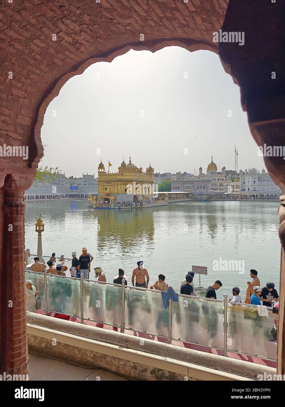 Sri Darbar Sahib Amritsar Sahib, la gente fa il bagno ad Amrit Sarovar - Immagine stock catturata con smartphone