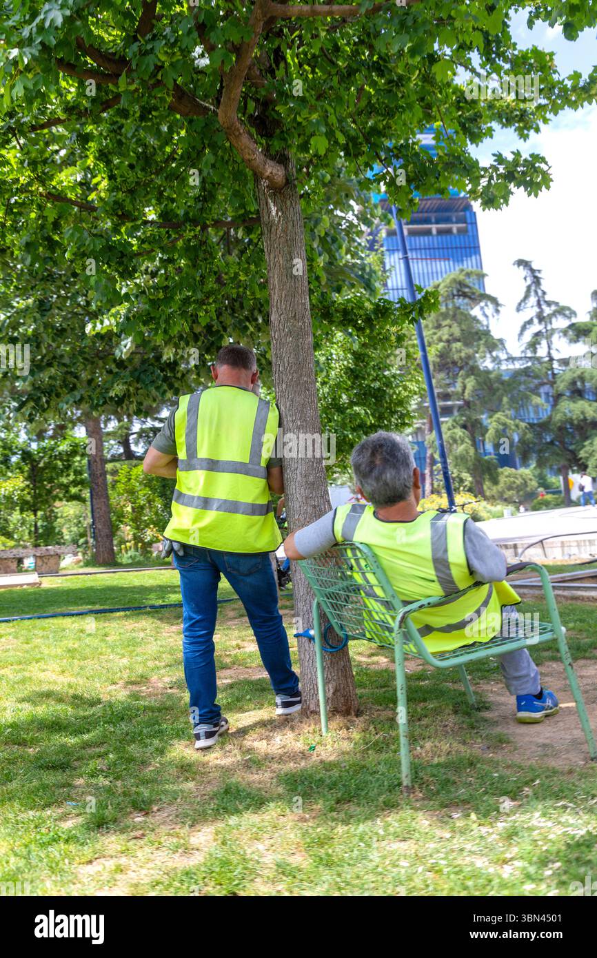 Operai in gilet gialli, si fanno una pausa Foto Stock