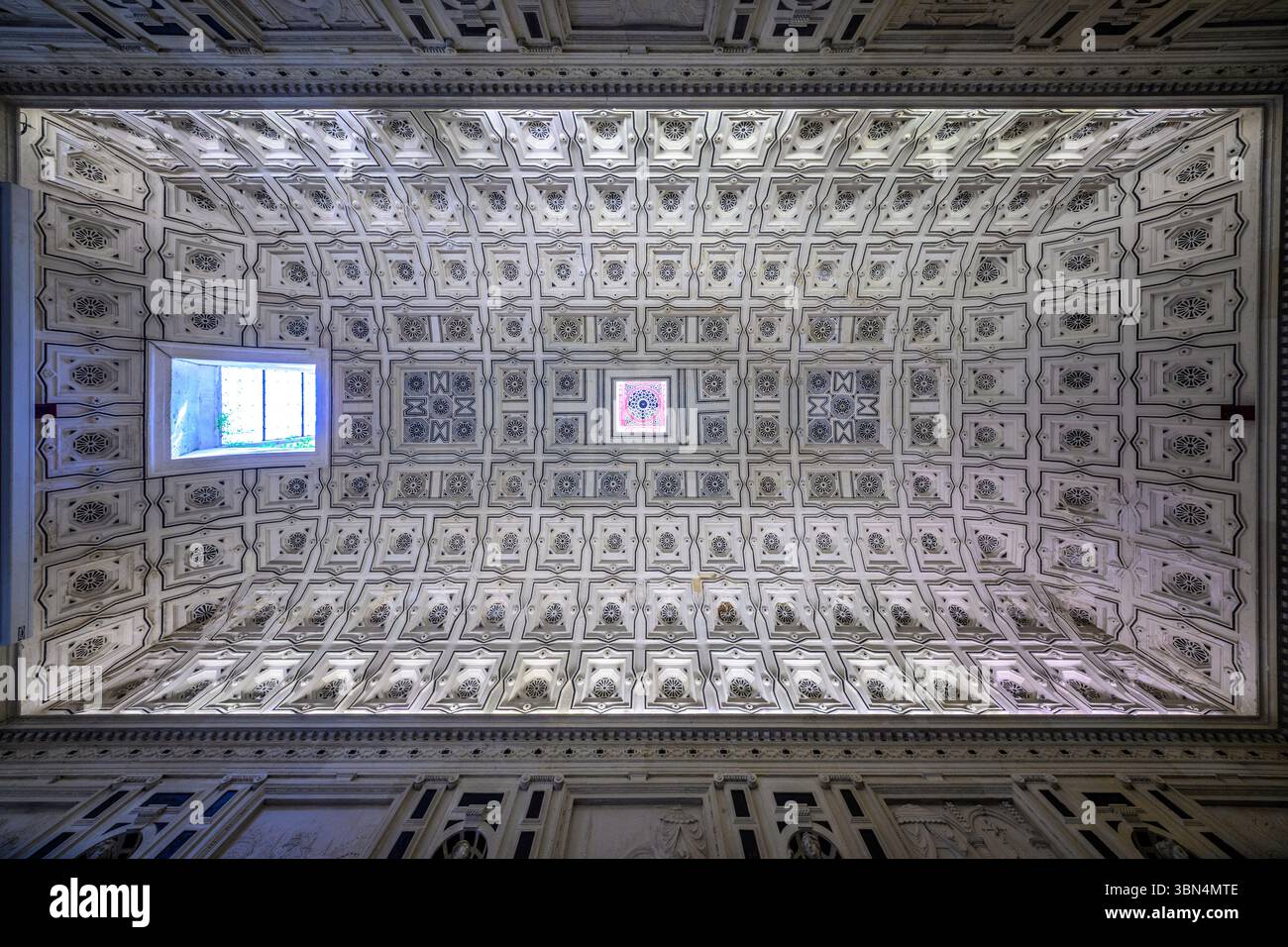 Soffitto splendidamente realizzato adornato con casse dorate e uno splendido oculus in vetro colorato, situato nella Cattedrale di Siviglia, Spagna. Foto Stock