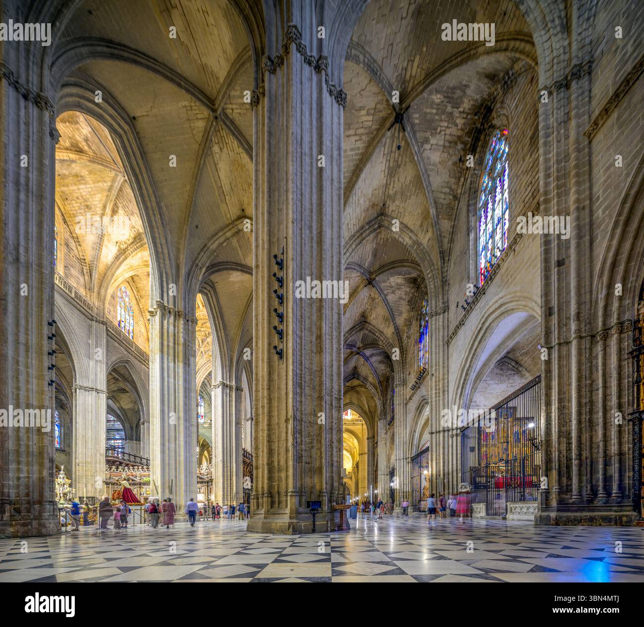 Siviglia, Spagna, 18 giugno 2025, i visitatori ammirano le splendide volte a coste e le vetrate colorate all'interno della cattedrale di Siviglia, un capolavoro di gotico Foto Stock