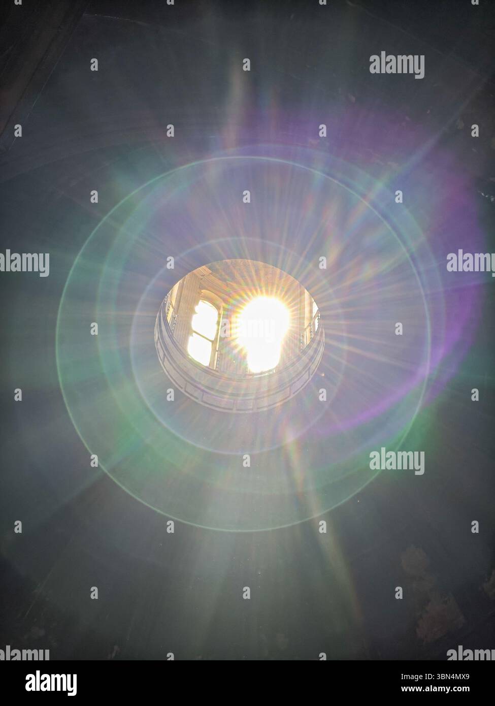 I raggi del sole esplodono attraverso la lanterna della cupola, illuminando la pietra secolare nella Chiesa di la Anunciacion, Siviglia, Andalusia. Foto Stock