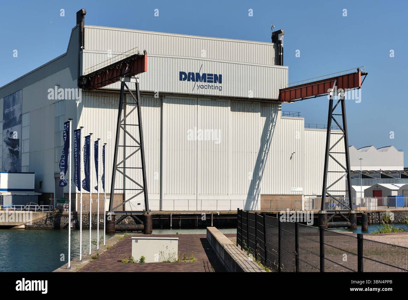 30 maggio 2025 - Vlissingen-Paesi Bassi: Vista frontale della sala Damen Yachting a Vlissingen con una banchina in primo piano con recinzione metallica e. Foto Stock