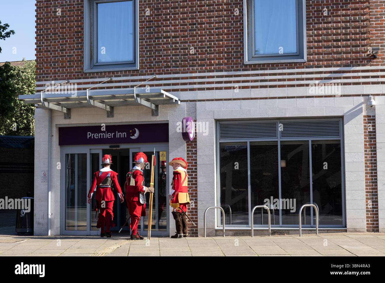 Attori vestiti in uniforme vittoriana di cavalleria fuori da una filiale del Premier Inn a Portsmouth's Historic Dockyard, Hampshire, Inghilterra, Regno Unito Foto Stock