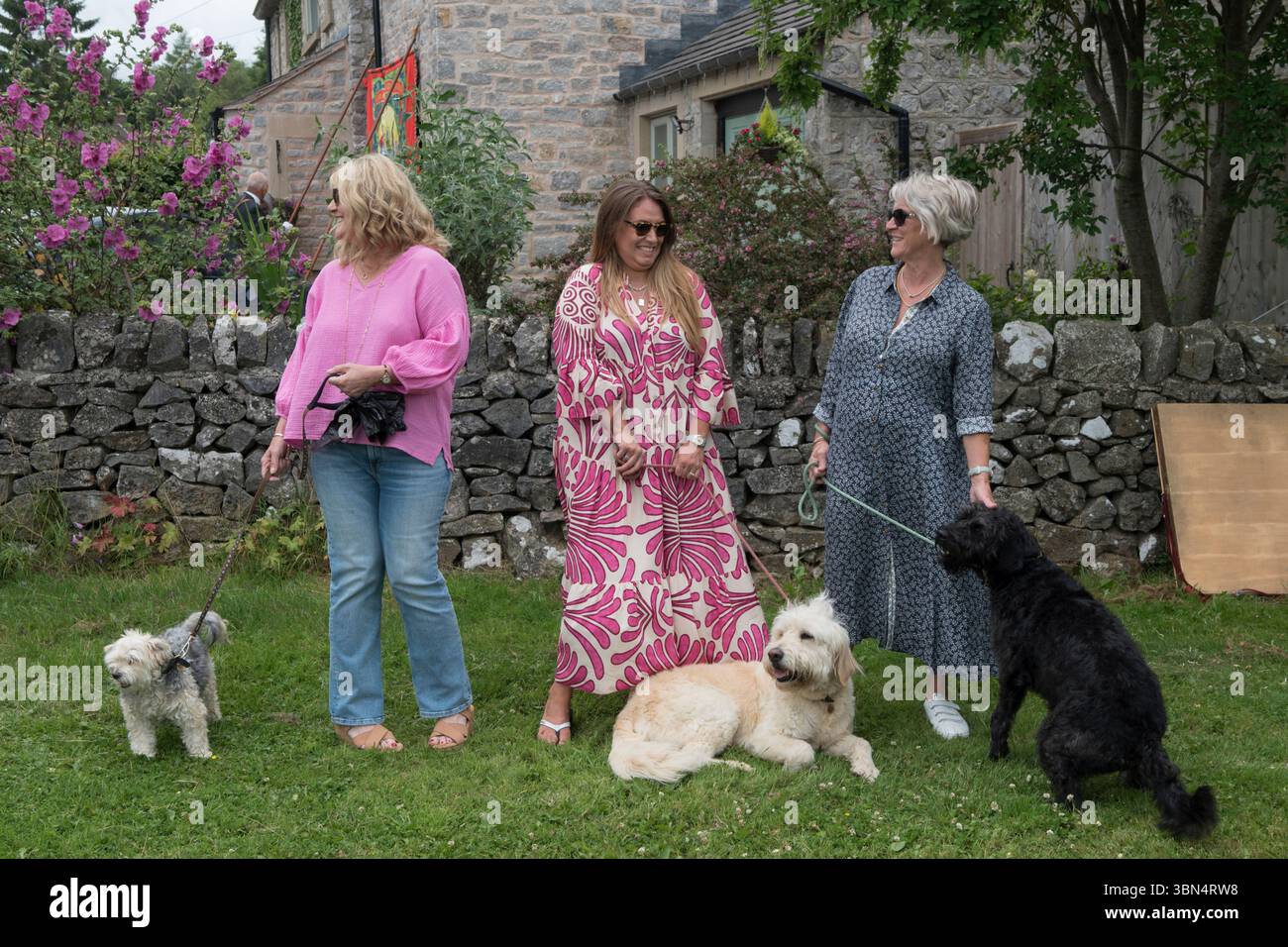 Donne inglesi, tre donne di mezza età della classe media con i loro cani. Parwich, Derbyshire, Inghilterra 1 luglio 2023 UK 2020s HOMER SYKES Foto Stock