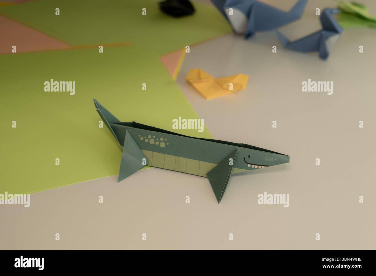 Squalo origami colorato e altri animali di carta su un tavolo Foto Stock